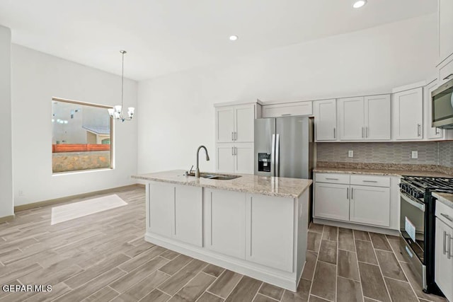 kitchen with white cabinetry, a center island with sink, appliances with stainless steel finishes, and a sink