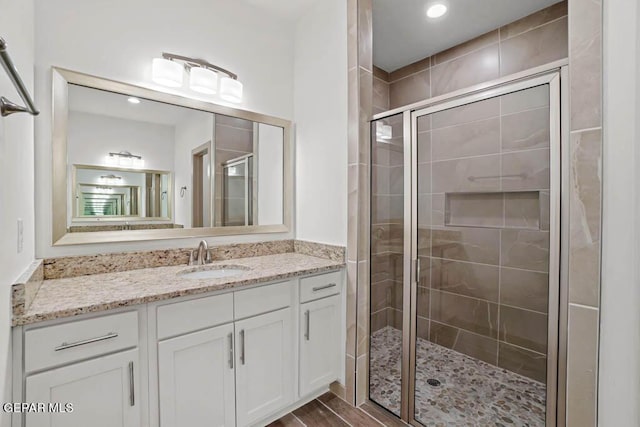 bathroom featuring a stall shower, vanity, and wood finished floors