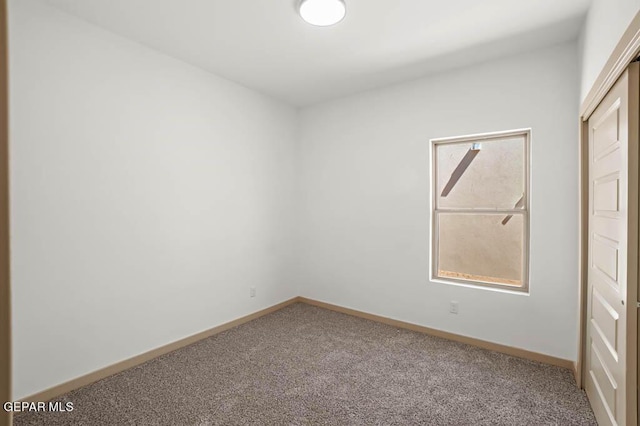 carpeted empty room with baseboards