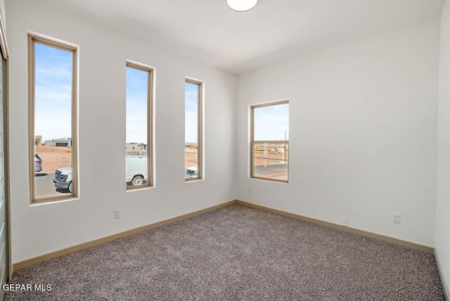 carpeted spare room with baseboards