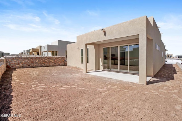 back of property with a patio area, fence, and stucco siding