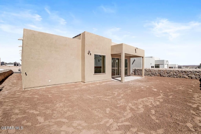 back of house featuring a patio area and stucco siding