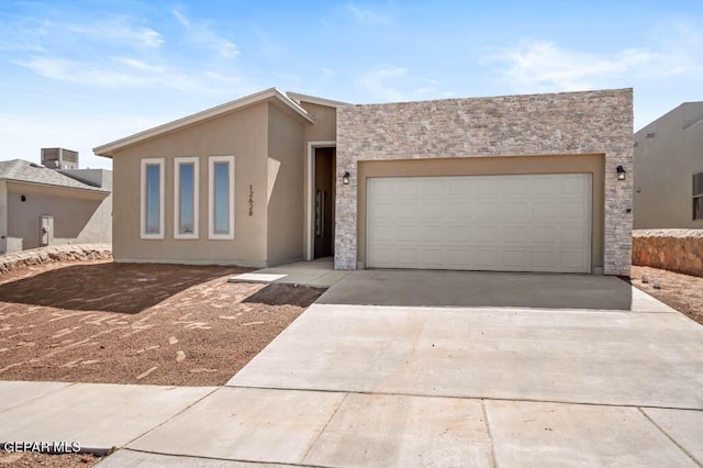 view of front of property with stone siding, concrete driveway, an attached garage, and stucco siding