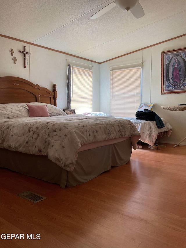 770 Eagles Den Ln, El Paso, TX 79927 - bedroom featuring a textured ceiling, wood finished floors, visible vents, a ceiling fan, and ornamental molding