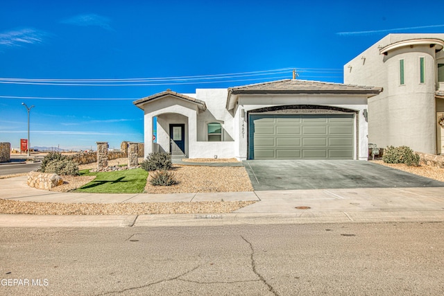 view of front of home with a garage, driveway, a tiled roof, and stucco siding