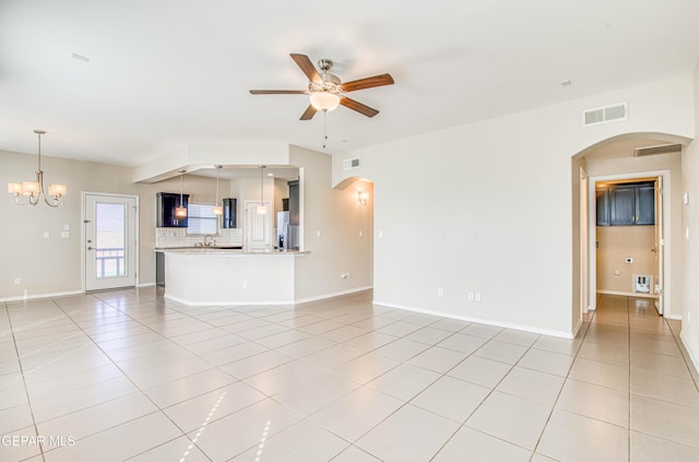 unfurnished living room with light tile patterned floors, baseboards, visible vents, arched walkways, and ceiling fan with notable chandelier