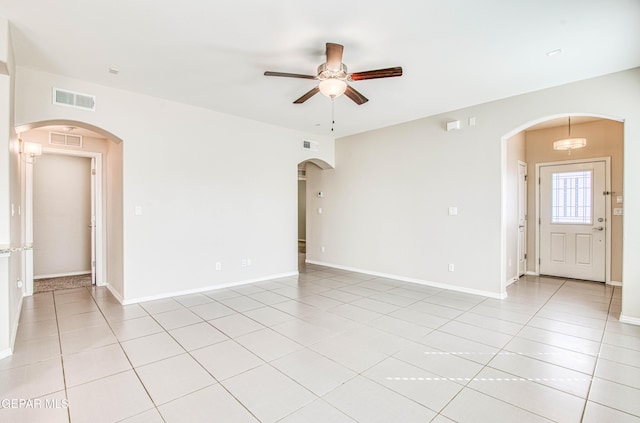 unfurnished room with arched walkways, ceiling fan, light tile patterned floors, and visible vents