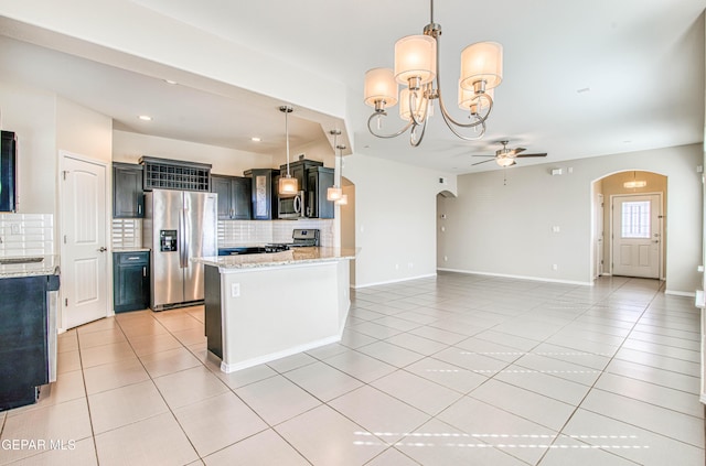 kitchen with stainless steel appliances, arched walkways, open floor plan, and light tile patterned floors