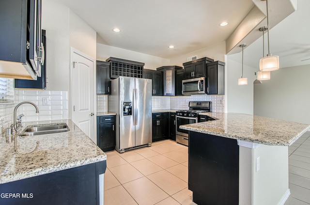 kitchen featuring light tile patterned floors, light stone countertops, stainless steel appliances, dark cabinetry, and a sink