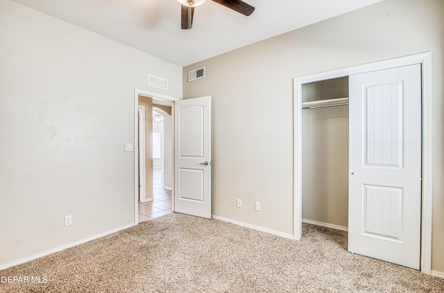 unfurnished bedroom with light colored carpet, a closet, visible vents, and ceiling fan