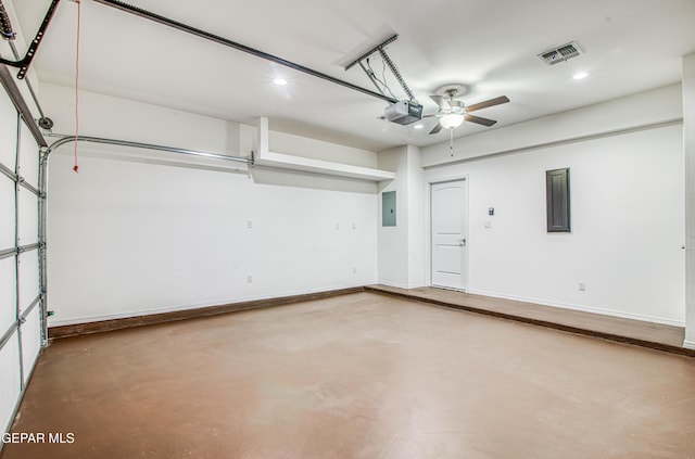 garage with baseboards, a garage door opener, visible vents, and electric panel