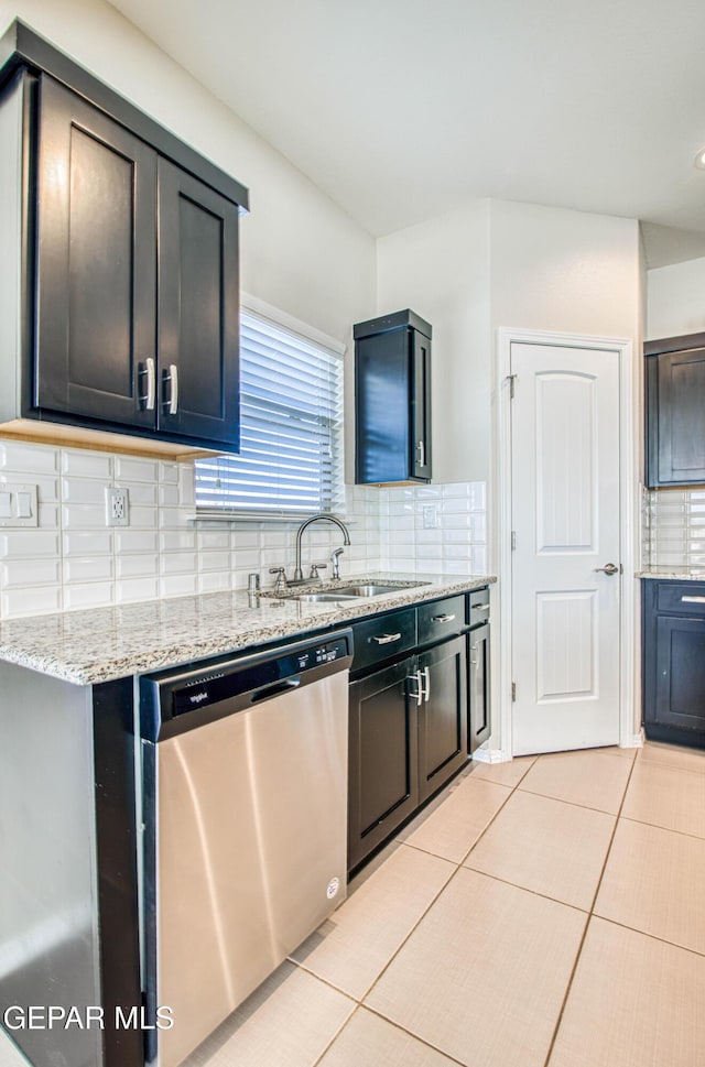 kitchen featuring dishwasher, backsplash, a sink, and light tile patterned floors