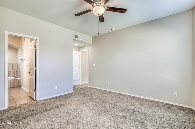 unfurnished bedroom featuring carpet, visible vents, connected bathroom, baseboards, and tile patterned floors