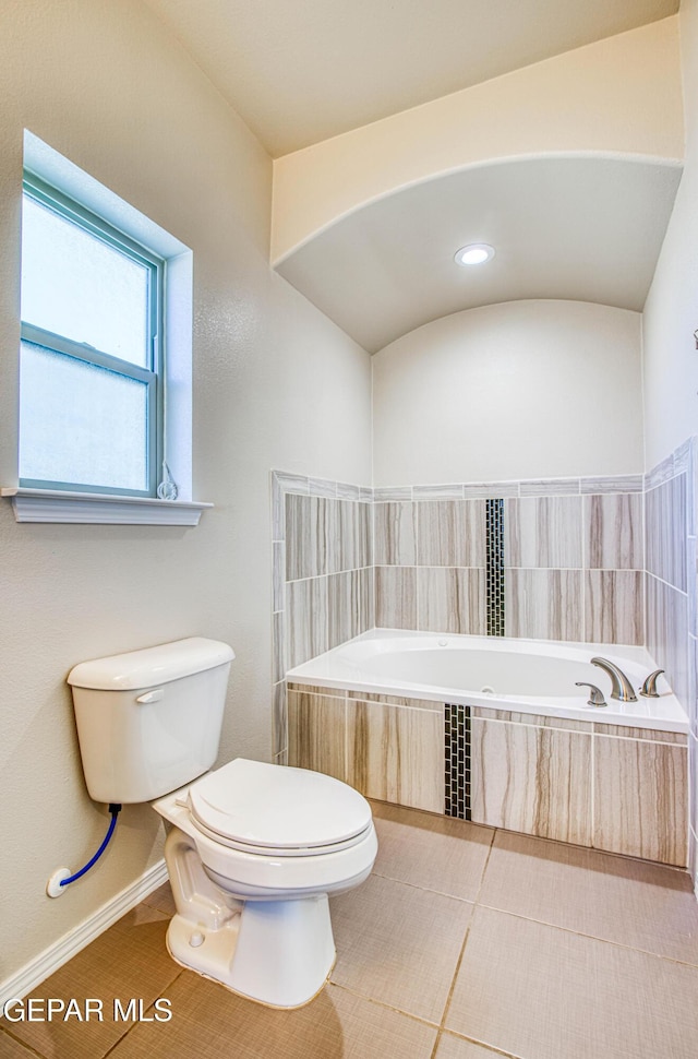 full bathroom with toilet, tile patterned flooring, baseboards, and a bath