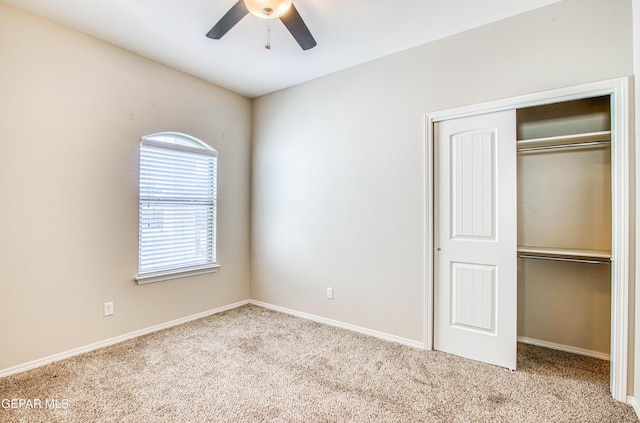 unfurnished bedroom featuring a closet, carpet flooring, a ceiling fan, and baseboards