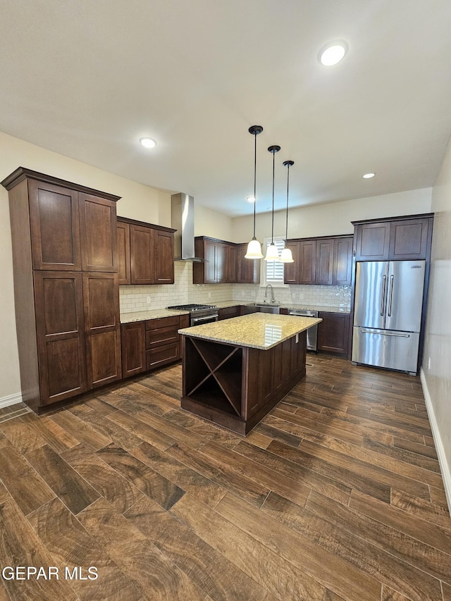 kitchen with a sink, dark brown cabinets, wall chimney range hood, decorative backsplash, and high end appliances