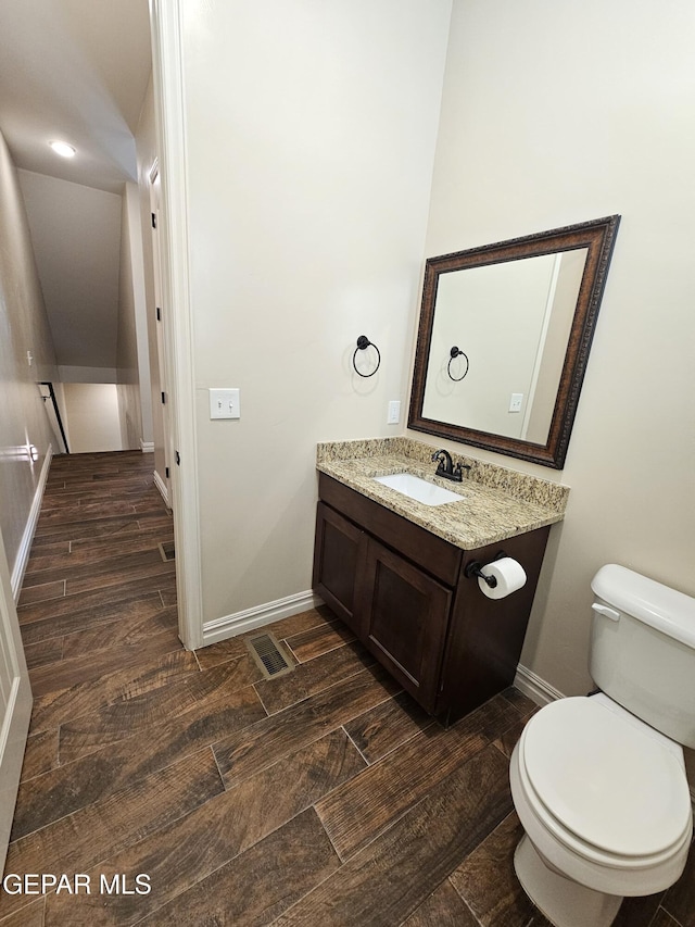 bathroom featuring wood tiled floor, visible vents, vanity, and toilet