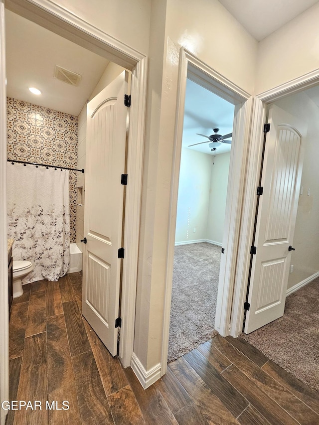 corridor with wood finish floors, visible vents, and baseboards