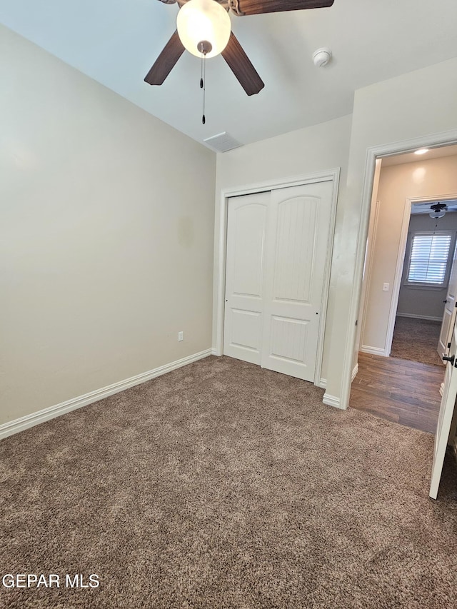 unfurnished bedroom with visible vents, baseboards, ceiling fan, carpet floors, and a closet