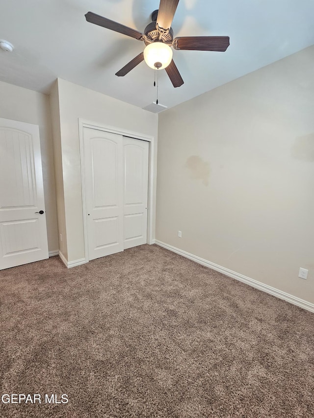 unfurnished bedroom with a closet, carpet flooring, a ceiling fan, and baseboards