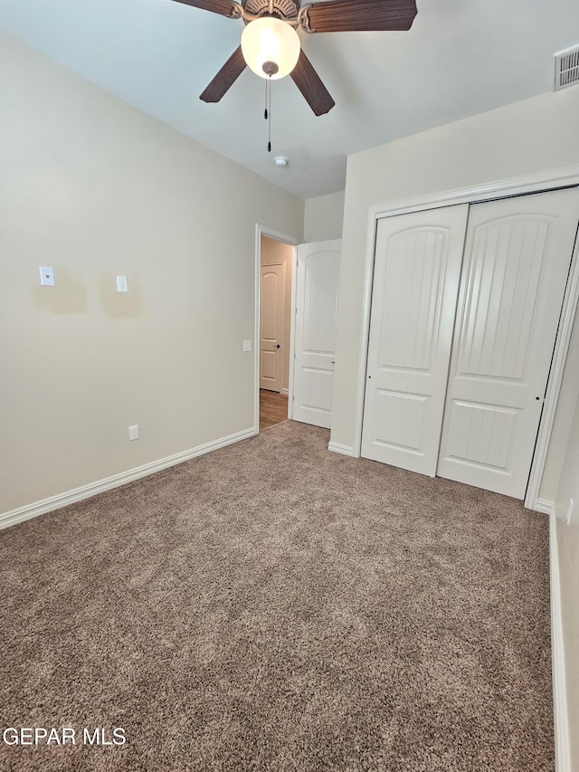 unfurnished bedroom with carpet, a closet, ceiling fan, and baseboards