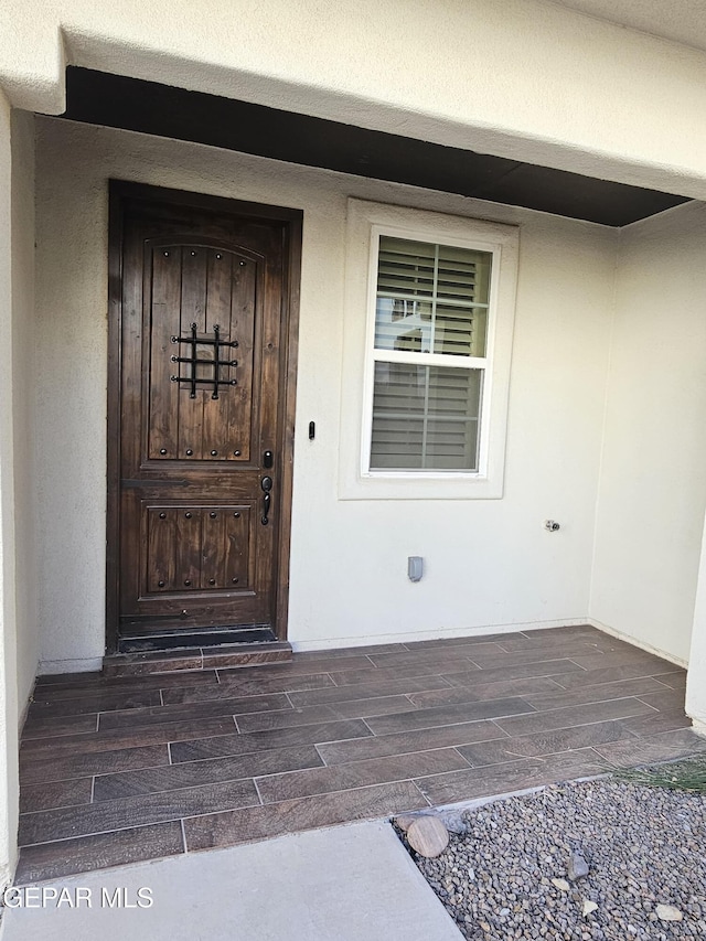 view of exterior entry featuring stucco siding