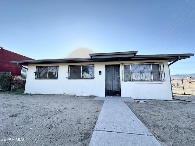 view of front of property with fence and stucco siding