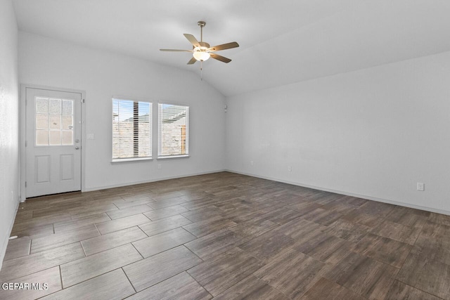 empty room featuring a ceiling fan, lofted ceiling, baseboards, and wood finished floors