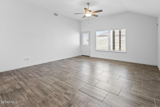 spare room featuring baseboards, visible vents, vaulted ceiling, and a ceiling fan