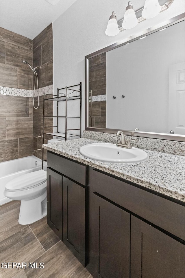 full bathroom featuring  shower combination, vanity, toilet, and wood finished floors