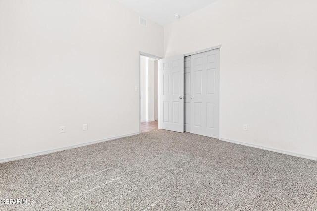 unfurnished bedroom with carpet floors, a closet, visible vents, and baseboards