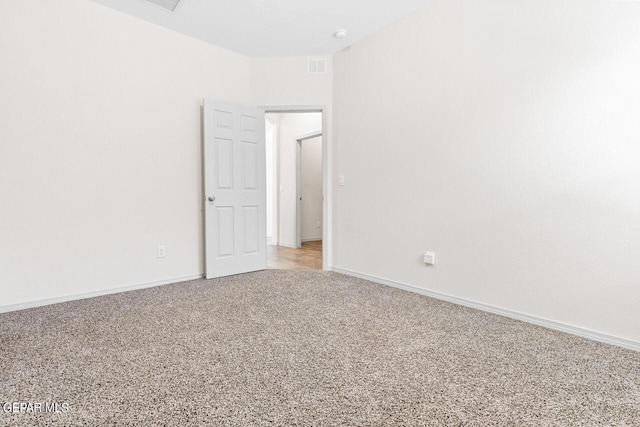 empty room featuring light carpet, visible vents, and baseboards