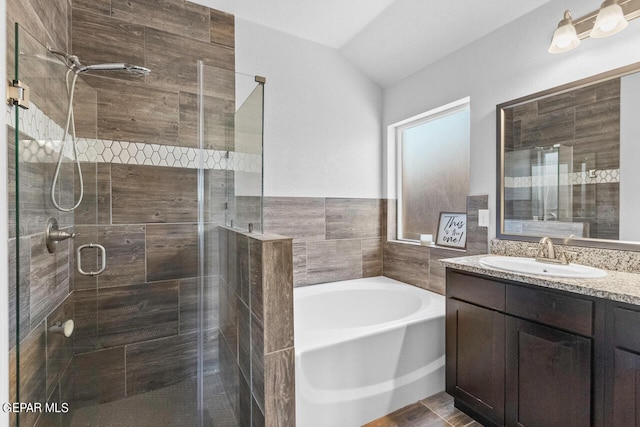 full bathroom with lofted ceiling, vanity, a shower stall, and a bath