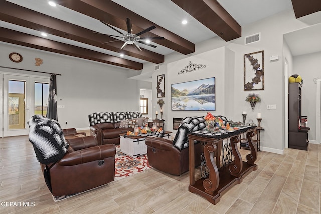 living area with light wood-style floors, beam ceiling, visible vents, and baseboards