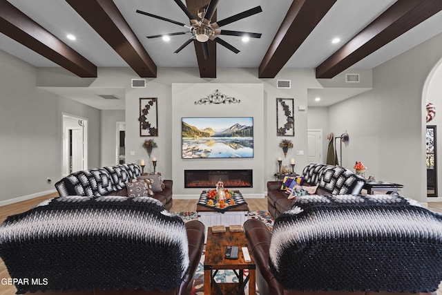 living room featuring baseboards, visible vents, and a glass covered fireplace