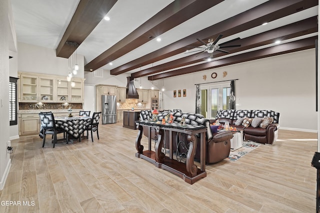 living room with light wood-style floors, baseboards, a ceiling fan, and beam ceiling