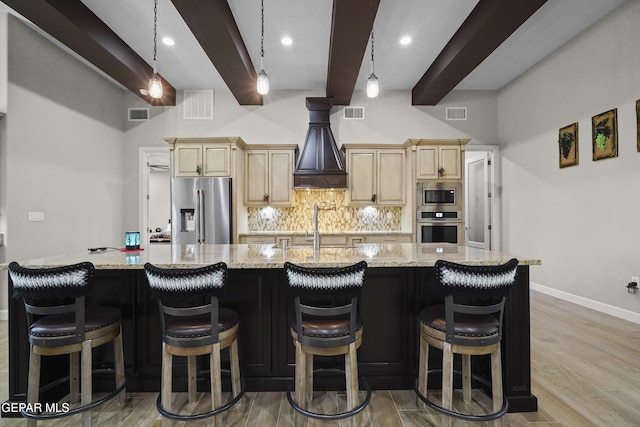 kitchen featuring beam ceiling, a spacious island, tasteful backsplash, visible vents, and appliances with stainless steel finishes