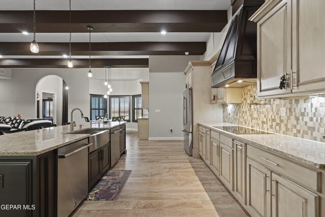 kitchen featuring arched walkways, decorative backsplash, custom range hood, stainless steel appliances, and beam ceiling