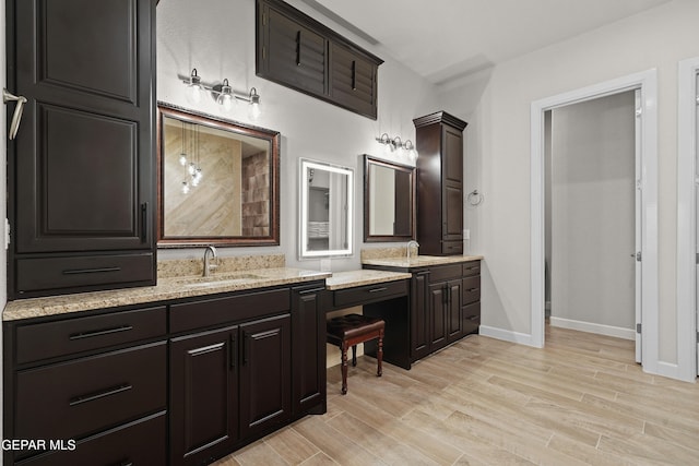 bathroom with vanity, baseboards, and wood finished floors