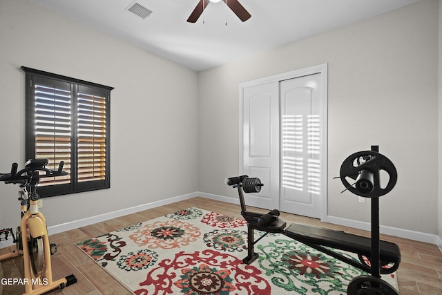 workout room featuring wood finished floors, visible vents, and baseboards