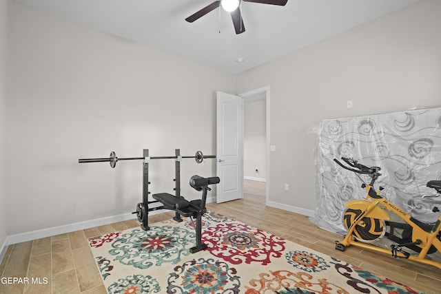 exercise area featuring wood finish floors, ceiling fan, and baseboards