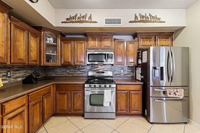 3537 Tierra Bahia Dr, El Paso, TX 79938 - kitchen with dark countertops, light tile patterned floors, visible vents, and appliances with stainless steel finishes