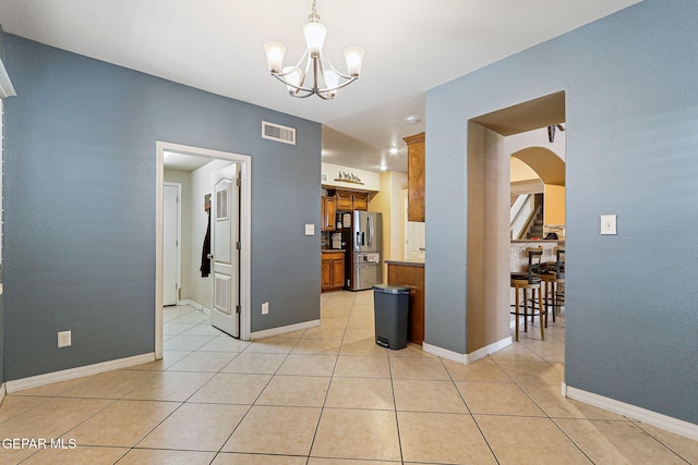 3537 Tierra Bahia Dr, El Paso, TX 79938 - interior space featuring arched walkways, visible vents, an inviting chandelier, light tile patterned flooring, and baseboards