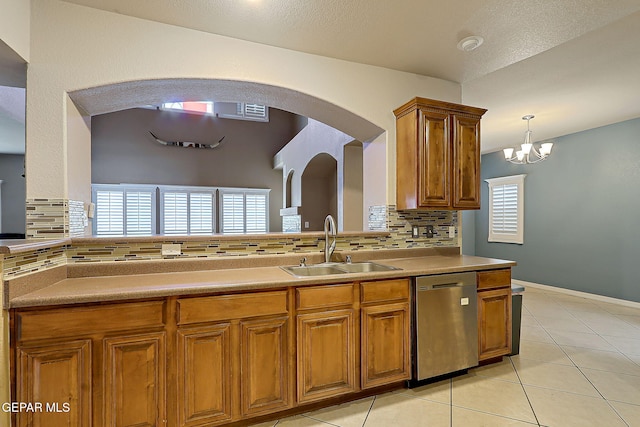3537 Tierra Bahia Dr, El Paso, TX 79938 - kitchen with light tile patterned floors, a sink, stainless steel dishwasher, tasteful backsplash, and brown cabinetry