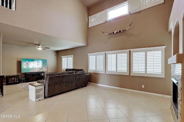3537 Tierra Bahia Dr, El Paso, TX 79938 - living room featuring a ceiling fan, a fireplace, baseboards, and light tile patterned floors
