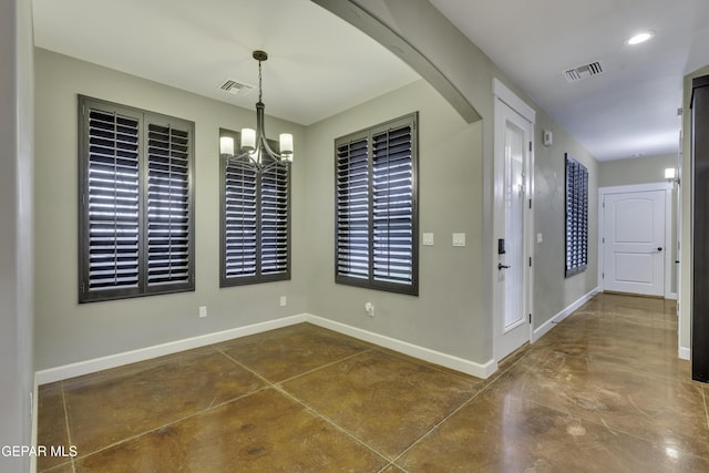 unfurnished dining area with a chandelier, visible vents, concrete flooring, and baseboards