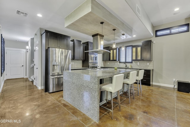 kitchen with baseboards, a kitchen island, appliances with stainless steel finishes, light stone counters, and pendant lighting