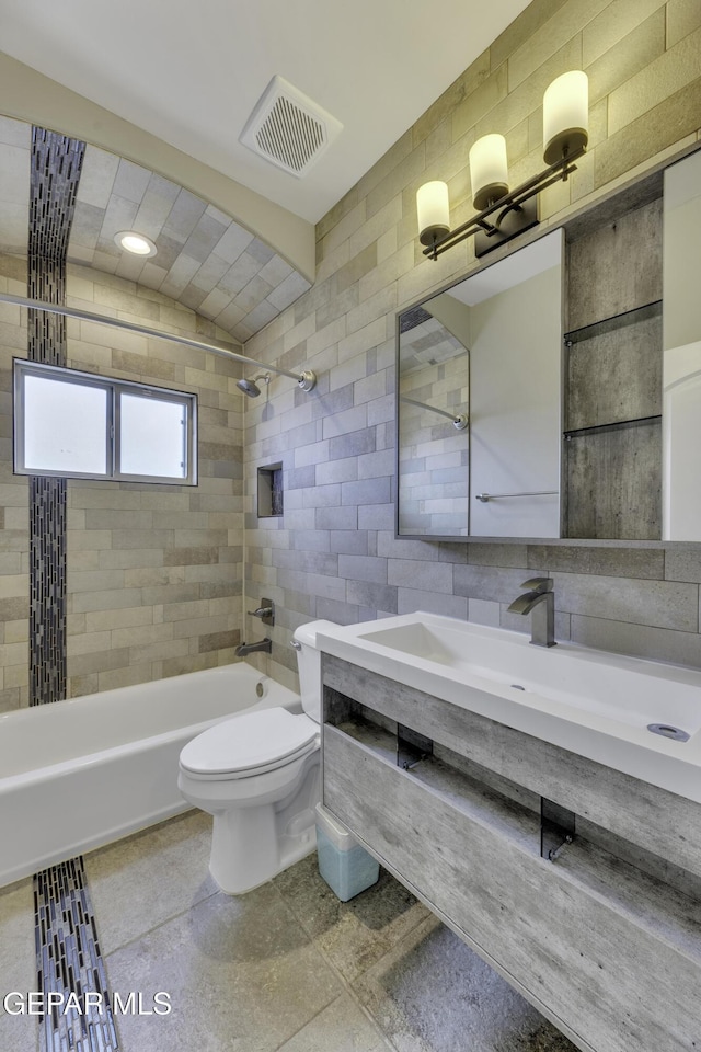 bathroom featuring shower / tub combination, toilet, visible vents, tile walls, and decorative backsplash