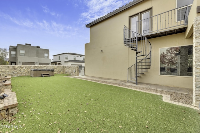 view of yard featuring a hot tub, stairs, and fence