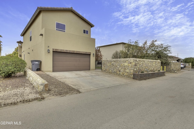 view of front facade featuring driveway, an attached garage, and stucco siding